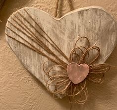 a heart hanging on the wall with some twine