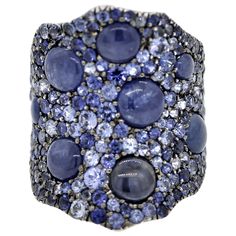 A lovely accent to any outfit! This gold ring features both smooth cabochon shaped sapphires along with round-brilliant cut blue sapphires. The cabochons weigh 4.16 carats while the round shaped sapphires weigh a total of 3.61 carats and are of different shades of blue giving the ring contrast in color. Made in 18k white gold and ready to be loved and enjoyed. Ring Size 6 Luxury Cabochon Round Cut Rings, Luxury Multi-stone Sapphire Gemstones, Luxury Blue Round Cabochons, Luxury Sapphire Cabochon Ring, Luxury Blue Cabochons For Anniversary, Blue Cabochon Sapphire Ring In Fine Jewelry Style, Fine Jewelry Sapphire Ring With Cabochon Cut, Fine Jewelry Sapphire Cabochon Ring, Fine Jewelry Blue Cabochon Sapphire Ring