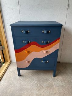 a blue dresser with multicolored waves painted on it