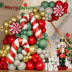 a christmas tree made out of balloons, candy canes and other holiday decorations in front of a staircase