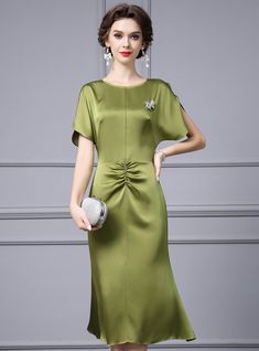 a woman wearing a green dress and white shoes