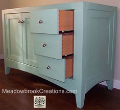 a blue dresser with three drawers on top of it