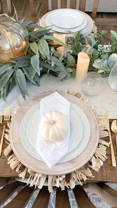 a table set with white plates and silverware