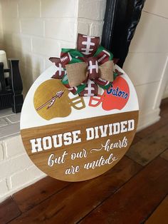 a wooden sign that says house divided but our hearts are with footballs on it