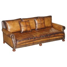 a brown leather couch sitting on top of a wooden frame