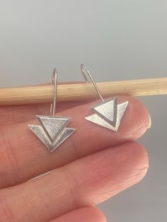 These geometric art deco inspired threader earrings have been handmade from recycled sterling silver and are really easy to wear - simply pull through and you're done! Measuring approximately 30mm full drop length by 15mm across, they are very lighweight and make a fabulous and unique gift. Everyday Silver Triangle Earrings, Modern Silver Threader Earrings With Ear Wire, Modern Silver Long Drop Threader Earrings, Modern Sterling Silver Threader Earrings, Modern Adjustable Sterling Silver Threader Earrings, Modern Silver Threader Earrings, Sterling Silver Triangle Jewelry With Matching Earrings, Handmade Sterling Silver Geometric Jewelry, Handmade Geometric Sterling Silver Jewelry