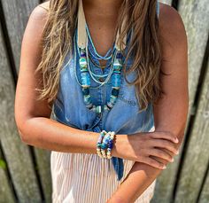 a woman with long hair wearing a necklace and bracelet