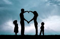 a family holding hands in the shape of a heart