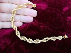 a person holding onto a gold chain bracelet