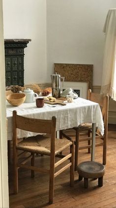 a dining room table and chairs with food on it