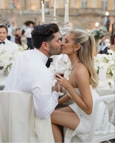 a man and woman sitting at a table kissing