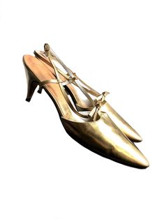 "vintage late 1950s to early 1960s gold leather pumps a beautiful pair of 50s 60s stiletto heels made of super soft genuine leather with a gold metallic finish. they are adorned with a little gold leather bow and designed with a long pointy nose and adjustable heel strap. stamped size : US 7 1/2 AAA  (modern size 7) brand: J. Miller in excellent vintage condition, minor wear on the bottom soles, very minimal scuff marks on the heels. the gold leather feels incredible soft and is in great conditi Gold Court Shoes With 4-inch Heel For Evening, Gold Fitted Court Shoes With Low Heel, Gold High Heel Court Shoes With 4-inch Heel, Gold Pointed Toe Kitten Heels With Sculpted Heel, Gold Round Toe Kitten Heels For Spring, Gold Court Shoes With 4-inch Heel And Almond Toe, Gold Kitten Heels With 4-inch Heel, Gold Leather Kitten Heels For Party, Gold Leather Low Kitten Heels