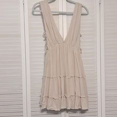 Nwt Arm Pits Have Criss Cross Tied. The Back Has Strings To Tie To A Bow. Casual Beige Sundress With Tie Straps, Sleeveless Neutral Mini Dress For Summer, Neutral Sleeveless Mini Dress For Summer, Cream Sleeveless Mini Dress For Summer, Cream Sleeveless Sundress For Brunch, Sleeveless Mini Dress With Knotted Straps For Beach, Cream Sleeveless Sundress For Beach, Sleeveless Neutral Mini Dress For Spring, Cream Sleeveless Sundress