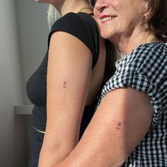 two women hugging each other in front of a window with the sun shining on them