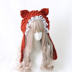 the wig is wearing a red knitted hat with ears on it's head