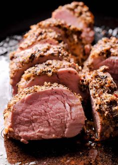 sliced meat sitting on top of a pan covered in seasoning