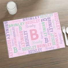 a place mat with the letter b on it next to a fork, spoon and cup