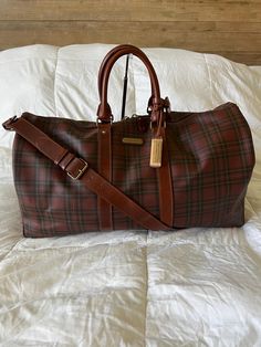 RALPH LAUREN Boston Travel Duffle Bag with Original Leather Shoulder Strap.  Unisex Coated Canvas Travel Bag.   Maroon Tartan Plaid,  Brown Leather Shoulder Strap, Top Zipper Close, Cloth Lined Interior with Reinforced Bottom , Brown Leather Lattice Bottom To Reinforce and Prevent Damage.   Vintage and In Fabulous Condition! Clean and Ready To Use!  22 inches = 55 cm (Keepall Bandolier 55) Ralph Lauren Duffle Coat, Designer Brown Tote Duffle Bag, Designer Brown Rectangular Duffle Bag, Designer Brown Travel Bag For Daily Use, Designer Brown Coated Canvas Travel Bag, Brown Designer Coated Canvas Travel Bag, Designer Brown Travel Bag With Leather Handles, Luxury Brown Duffle Bag With Detachable Strap, Designer Brown Duffle Bag With Leather Handles