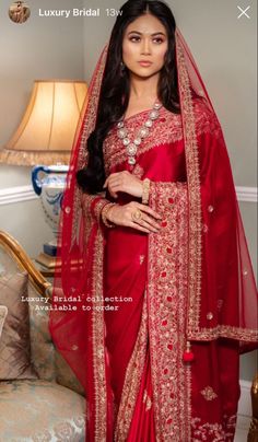 a woman in a red sari and gold jewelry is posing for the camera with her hands on her hips