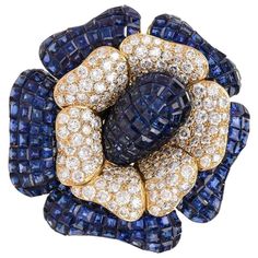 This outstanding Collectable flower brooch pin was designed by Sabbadini, Italy. It is handcrafted in solid 18K yellow gold weighing approx. 69.9 grams. It features a flowerhead design of bombé calibrated step-cut high quality royal blue genuine sapphires petals (in invisible mystery setting which was originally developed by Van Cleef and Arpels) all approx. 46.00 carats and Approx. 9.00 carats of diamonds, White H color, Very Clean VS Clarity. With an openwork back this enchanting brooch pin is Diamond Flower Brooch, Van Cleef And Arpels, Antique Pendant, Antique Brooches, Diamond Brooch, Mom Jewelry, Gold Brooches, Diamond Flower, Pearl Pendant Necklace