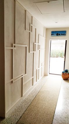 an empty hallway with white walls and beige carpeting on the floor next to a door