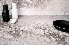 two black and white objects are sitting on the counter next to each other in front of a stone wall