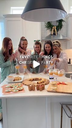 a group of women standing around a kitchen counter with food on top of it and the words favo rite things christmas party