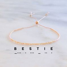 This handmade adjustable string bracelet -- with 'BESTIE' spelled out in Morse Code -- will remind your best friend what she means to you. + says 'BESTIE' in Morse Code + glass seed beads on blush silk cord + adjustable from 5" - 9" + all Libby & Smee beaded bracelets come packaged on a logo card in a clear resealing bag for storage and gift giving Also available in 'MOM', 'SISTER', 'HOPE', and 'ALWAYS'. Prefer a different word? No problem! Choose the "Custom Bracelet" option and write your word Dainty Adjustable Beaded Bracelets For Friendship, Minimalist Adjustable Beaded Bracelet For Bridesmaids, Adjustable Minimalist Beaded Bracelet For Bridesmaids, Handmade Adjustable Beaded Bracelets As Bridesmaid Gifts, Handmade Adjustable Beaded Bracelets For Bridesmaids, Dainty Adjustable Beaded Name Bracelet, Adjustable Gold Beaded Bracelets As Best Friend Gift, Dainty Beaded Adjustable Name Bracelet, Adjustable Gold Beaded Bracelets For Best Friend