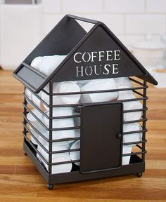 a coffee house shaped container filled with lots of white pillows and sitting on top of a wooden table