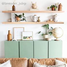 a living room filled with lots of furniture and bookshelves above a green cabinet