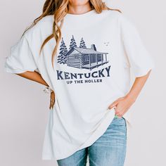 Show your team spirit and rock a vintage look with our Kentucky Log Cabin Shirt. This classic college t-shirt is a must-have for any Kentucky Wildcats fan or university student looking to showcase their pride in style. 🏀 Get ready to cheer on the Kentucky Wildcats with this retro-inspired design. Whether you're heading to a game day event or simply want to show your support, this t-shirt is the perfect choice. Let everyone know which team you're rooting for! 🎓 Made with comfort and style in mind, this vintage college t-shirt features a soft and durable fabric that feels great against your skin. Its timeless crewneck design and relaxed fit make it a comfortable choice for everyday wear or game day festivities. 🏆 With its Kentucky-inspired graphics, this shirt captures the essence of coll Rustic Relaxed Fit Tops For Fall, Country Style Cotton Tops With Relaxed Fit, Country Style Cotton Tops For Fall, Vintage College Shirts, Mission Trip Shirts, Kentucky Shirts, Trip Shirts, Mission Trip, University Tshirt