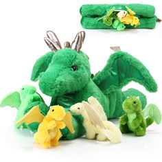 several stuffed animals are laying on the floor together, including a dragon and other toys