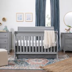 a baby's room with gray furniture and blue curtains