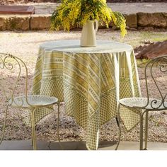 a table with two chairs and a vase filled with yellow flowers