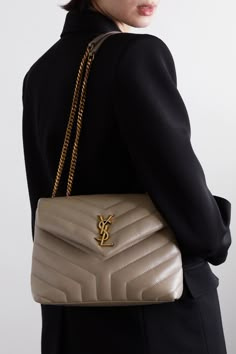 Originally created by graphic designer Adolphe Jean-Marie Mouron in 1962, SAINT LAURENT's iconic 'YSL' monogram continues to be recognized as an assurance of quality and luxury. This quilted 'Loulou' bag has been made in Italy from smooth leather detailed with signature chevron stitching. Though compact, it has a well-organized interior with two compartments, a zipped pocket and three card slots. Ysl Bag Outfit, Ysl Loulou Bag, Dream Bag, Ysl Logo, Bag Dark, Purse Brands, Dior Handbags, Bag Collection, Small Quilts