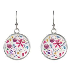 a pair of earrings with flowers painted on the front and back of each earring