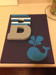 the letter b is made out of plastic and has a whale on it