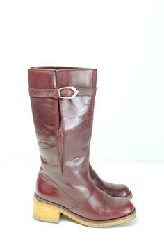 Vintage 70's Etienne Aigner burgundy leather boots.  Knee high.  Slightly rounded square toes.  Buckle at the calf.  Textured rubber sole.  Condition: Very good condition.  Only light wear.Brand: Etienne AignerMaterial: Leather upper, rubber soleSize: 5 1/2Length inside from heel to toe: 8 3/4 in.Heel width inside: 2 1/4 in.Ball outside: 2 7/8 in.Boot height: 11 1/2 in.Calf circumference: 12 1/2 in. Vintage Boots With Leather Sole And Square Toe, Fall Burgundy Boots With Leather Lining, Burgundy Leather Knee-high Boots, Burgundy Leather Square Toe Boots, Retro Leather Knee-high Boots With Round Toe, Vintage Wide Calf Mid-calf Boots With Round Toe, Retro Leather Boots With Square Toe, Retro Square Toe Leather Boots, Vintage Leather Boots With Low Heel