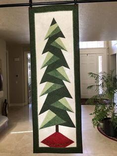 a green and red christmas tree hanging on a wall