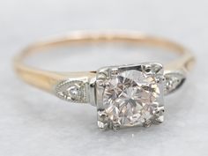 This two tone engagement ring features a yellow gold shank and a white gold head, complimented by sparkling diamond accents. Complete with a GIA certified diamond, this elegant ring exudes timeless beauty and sophistication. Perfect for expressing your everlasting love!Metal: 14K Yellow and White GoldGem: Diamond .73 Carats, I1 in Clarity, M in Color Gem Measurements: 5.6 mm, RoundAccents: 2 Diamonds totaling .02 Carats, SI in Clarity, J in ColorRing Size: 8.25Marks: "14K" Stamped on the inside bandGIA Report Number: 5201556638 Two Tone Engagement Ring, Two Tone Engagement Rings, Retro Ring, Sparkling Diamond, Everlasting Love, Colored Gems, Elegant Ring, Gia Certified Diamonds, Gia Diamond