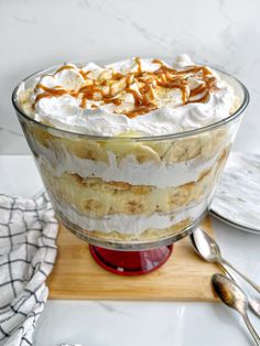 a banana split trifle with whipped cream and caramel drizzle on top