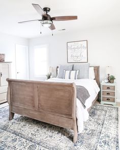 a bed room with a neatly made bed and a ceiling fan