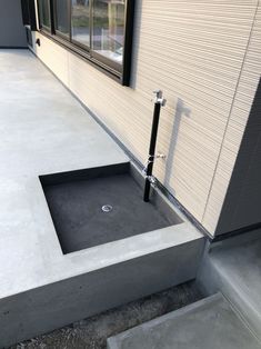 a concrete sink in front of a window on the side of a building with stairs leading up to it