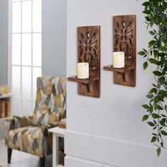 two candle holders are on the wall next to a chair