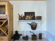 a shelf filled with lots of different items on top of a white tiled floor next to a wooden cabinet