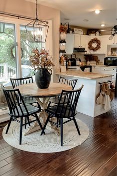 a kitchen and dining room with wood floors, white cabinets and an open floor plan