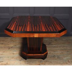 a wooden table sitting on top of a hard wood floor next to a black door