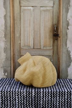 a brown hat sitting on top of a black and white checkered table cloth next to a wooden door