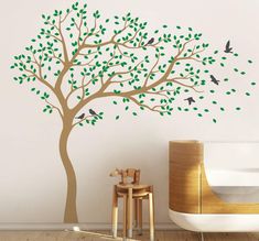 a tree with green leaves and birds on the branches is shown in this children's room