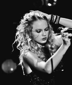 a woman with long blonde hair and bracelets on her arm, in black and white